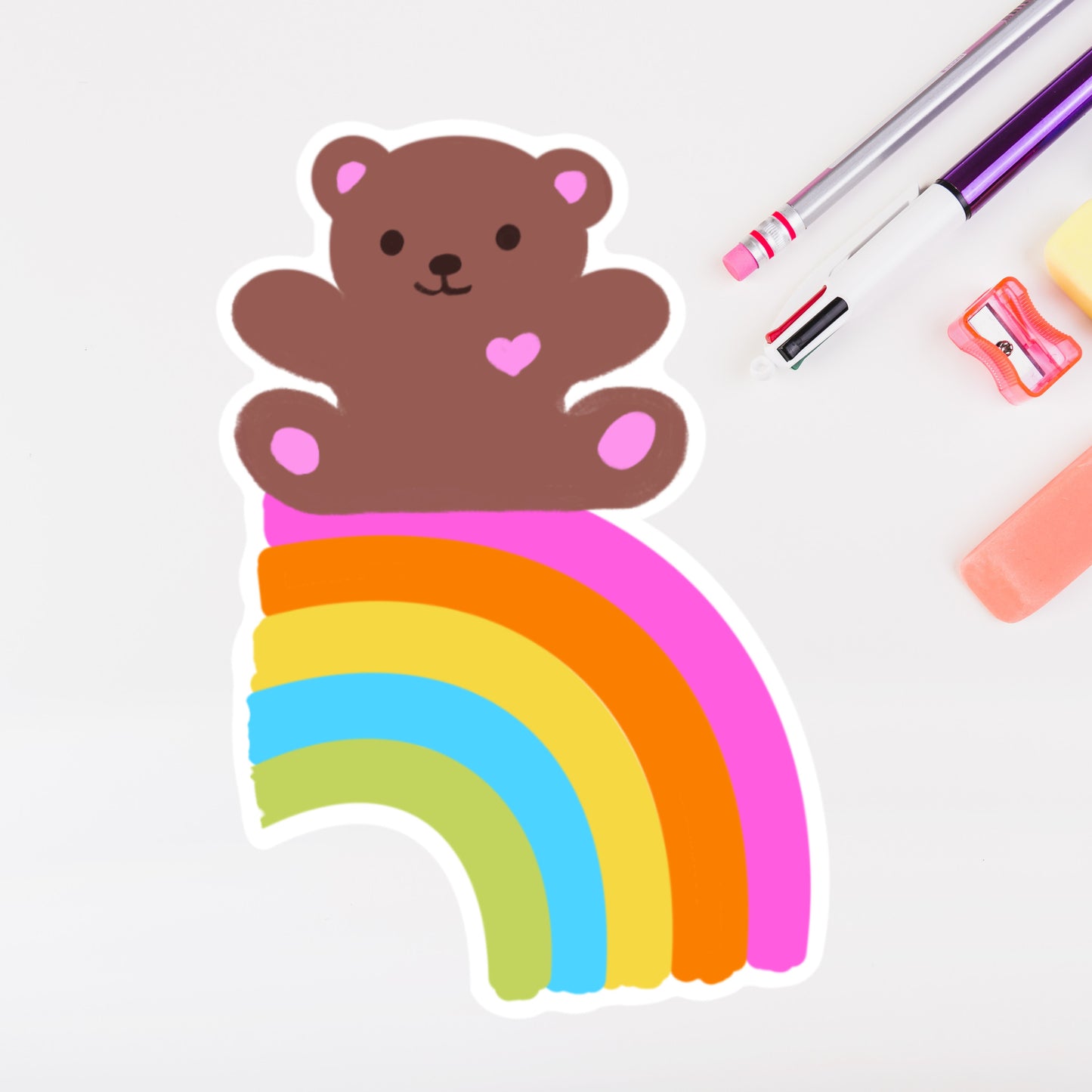 image of diecut Sticker of a bear with pink hearts on a rainbow.